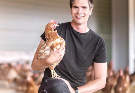René Esser mit einem Huhn vom Hof, © Familie Eich