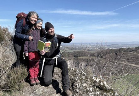 Sven Nieder, Laali Lyberth und Tochter Nivikka lieben es, auf Entdeckungstour durch die Eifel zu gehen – natürlich auch mit einem Geo-Reiseführer extra für Familien, der in ihrem Verlag erschien, © Kraterleuchten Verlag