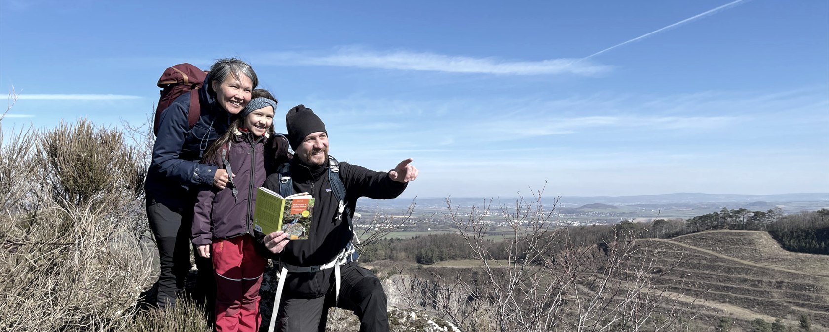 Sven Nieder, Laali Lyberth und Tochter Nivikka lieben es, auf Entdeckungstour durch die Eifel zu gehen – natürlich auch mit einem Geo-Reiseführer extra für Familien, der in ihrem Verlag erschien, © Kraterleuchten Verlag